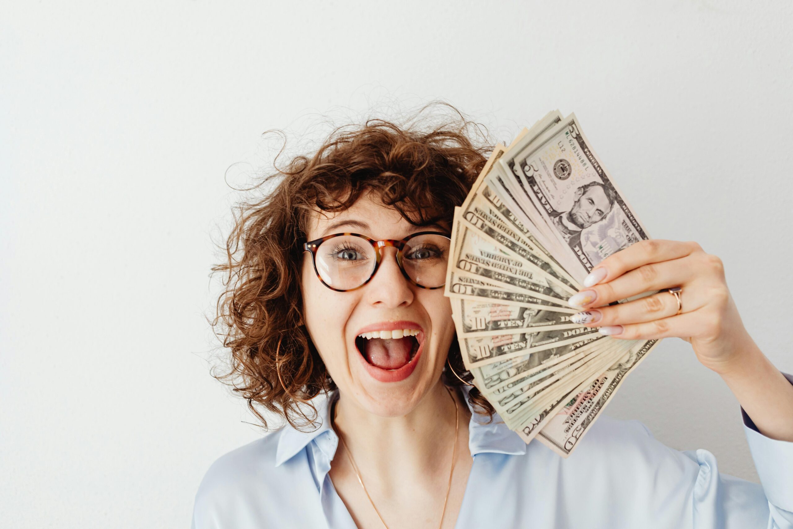 Illustration of a person standing atop a mountain of coins, symbolizing financial freedom and wealth growth strategies.-Teluguways.com