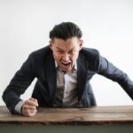 Illustration of stress in modern life with a person overwhelmed by work, technology, and societal pressures- Teluguways.com