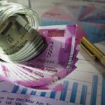 A business professional analyzing documents with graphs and charts, symbolizing various types of business loans in India and their benefits.Teluguways.com